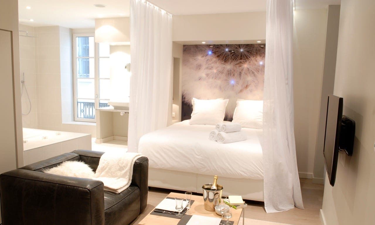 Chambre d’hôtes avec lit à rideaux et fresque étoilée