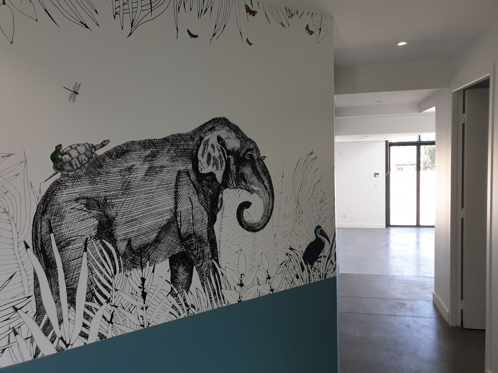 Couloir avec papier peint panoramique à motif d’éléphant et soubassement bleu