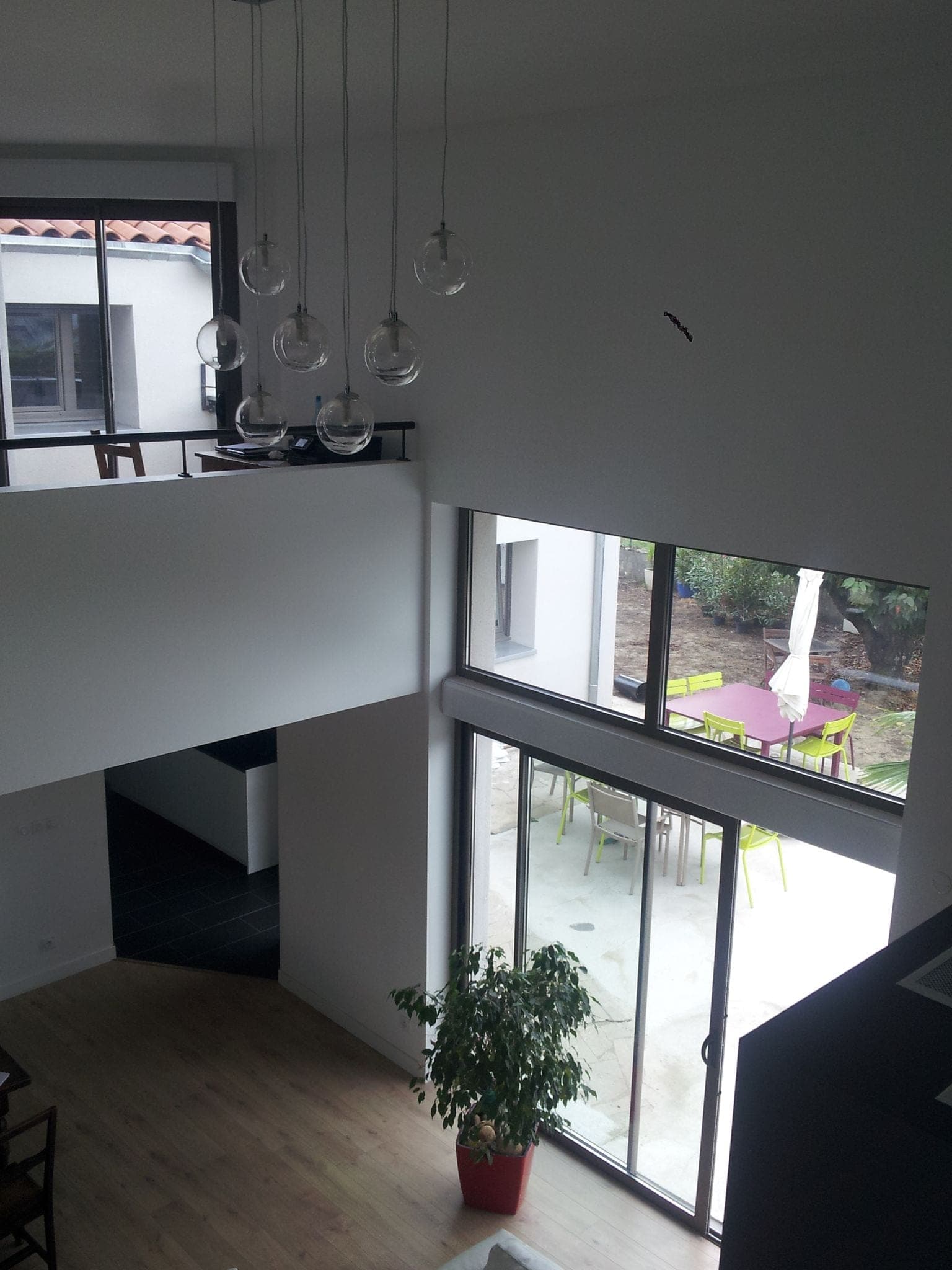 Volume en double hauteur avec mezzanine, suspensions en verre et grandes baies vitrées