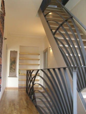 Escalier tournant avec rampe métallique aux courbes sculpturales