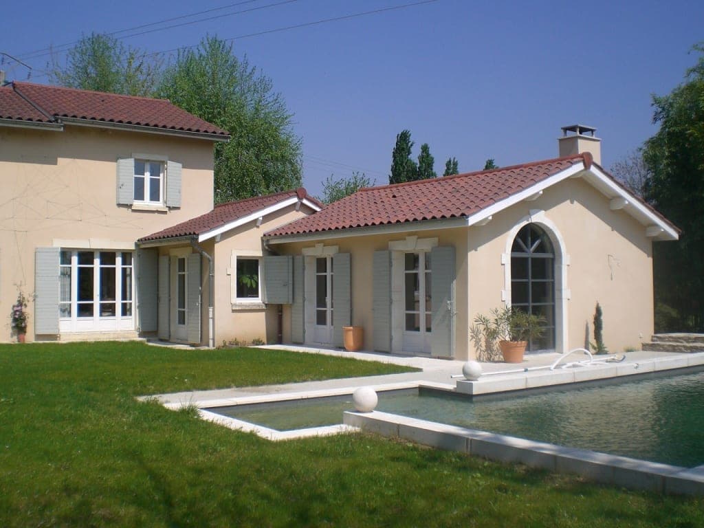 Maison aux volets gris avec bassin de baignade naturel