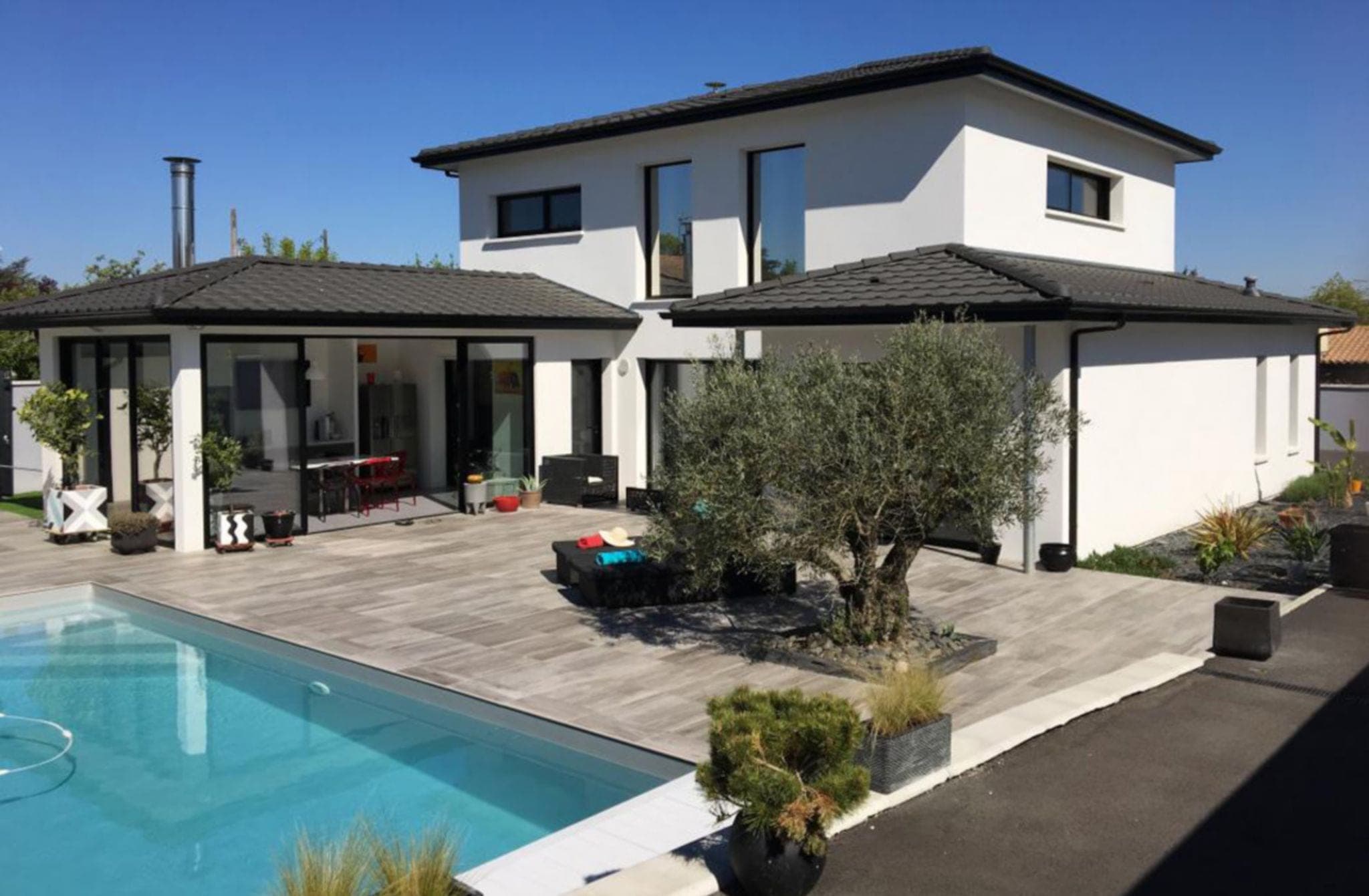Maison contemporaine avec toiture en tuiles, piscine et olivier