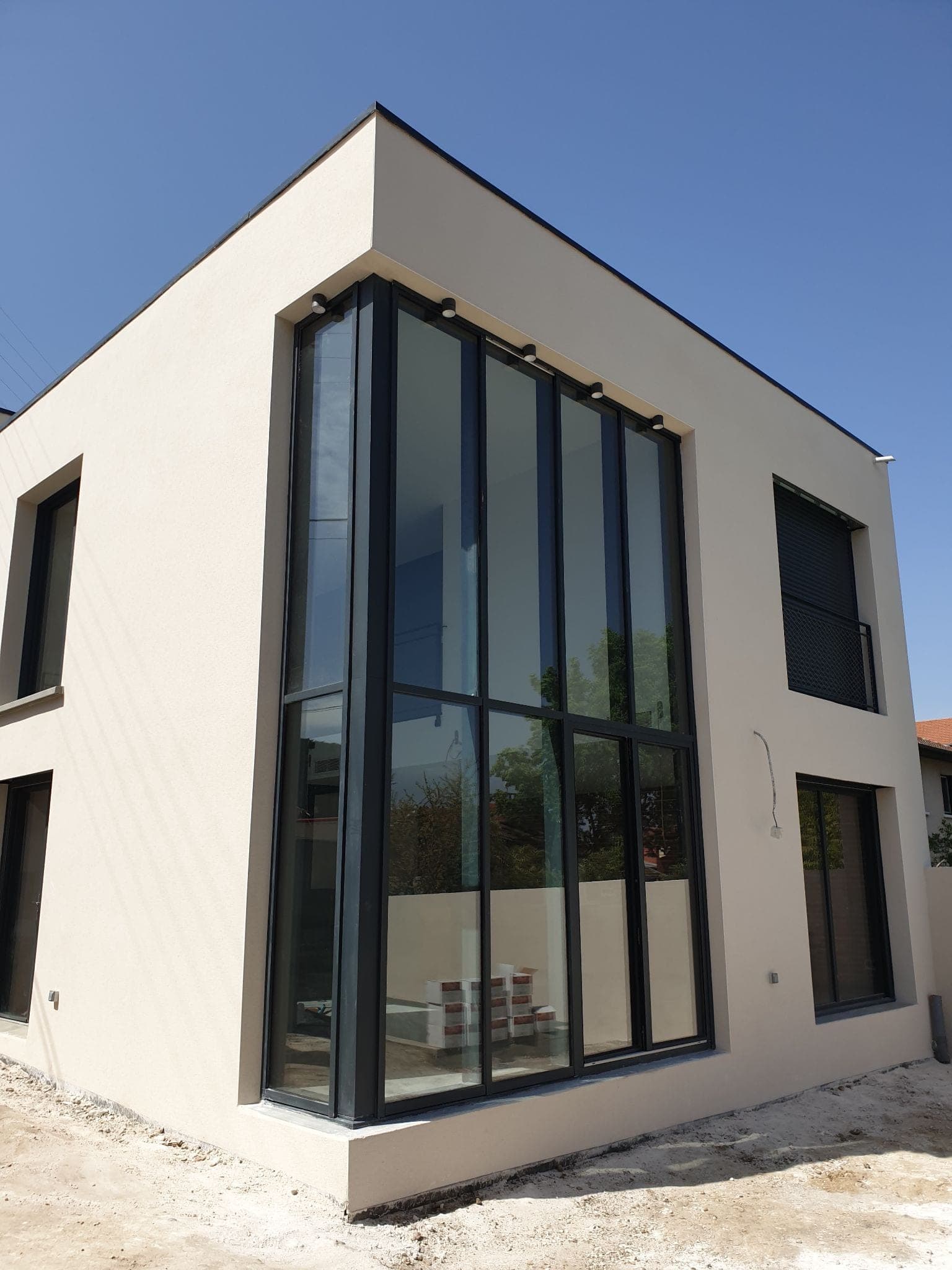 Maison cubique blanche avec baies vitrées toute hauteur