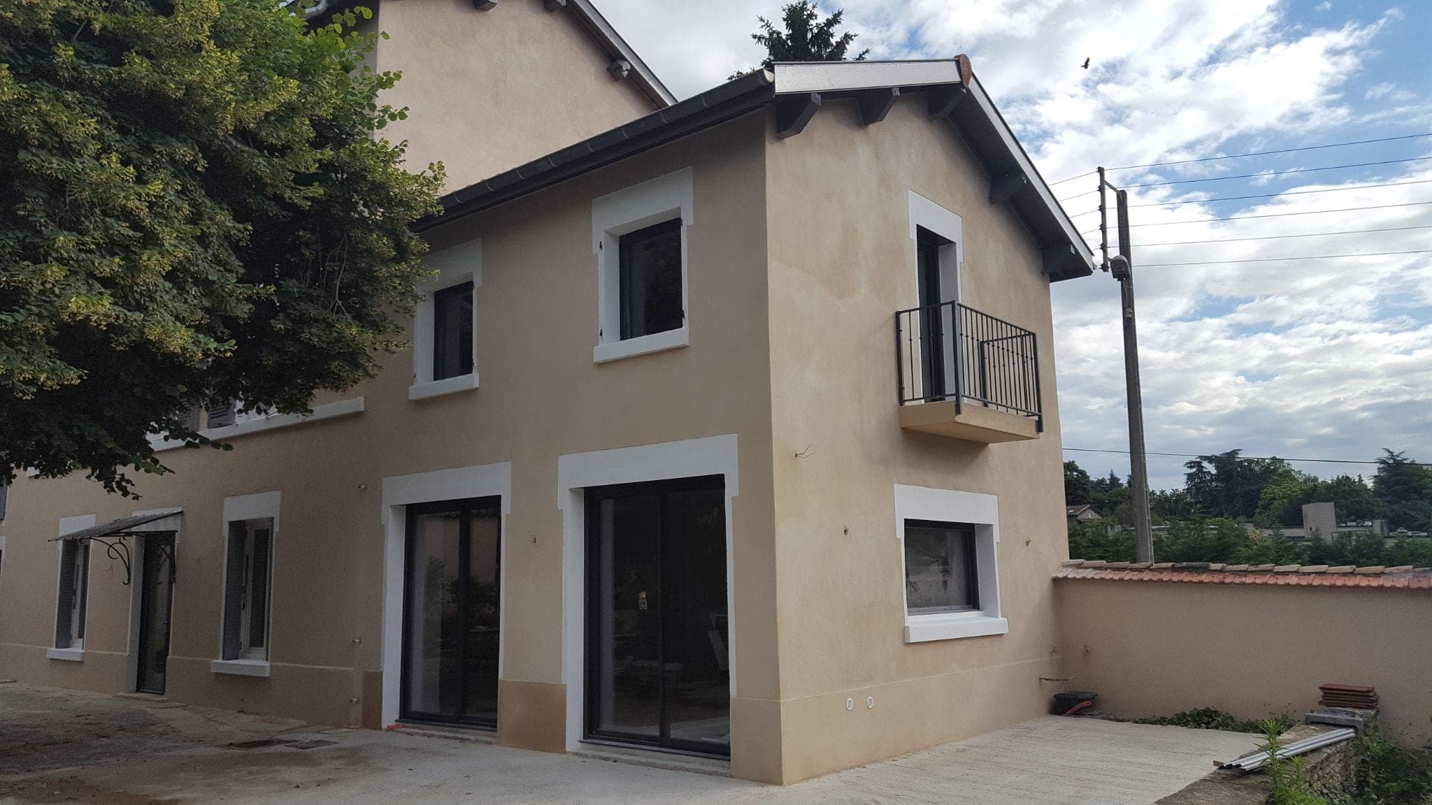 Maison de deux étages avec enduit neuf et menuiseries noires