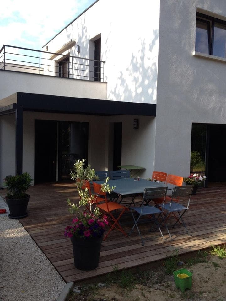 Maison contemporaine avec balcon et terrasse en bois