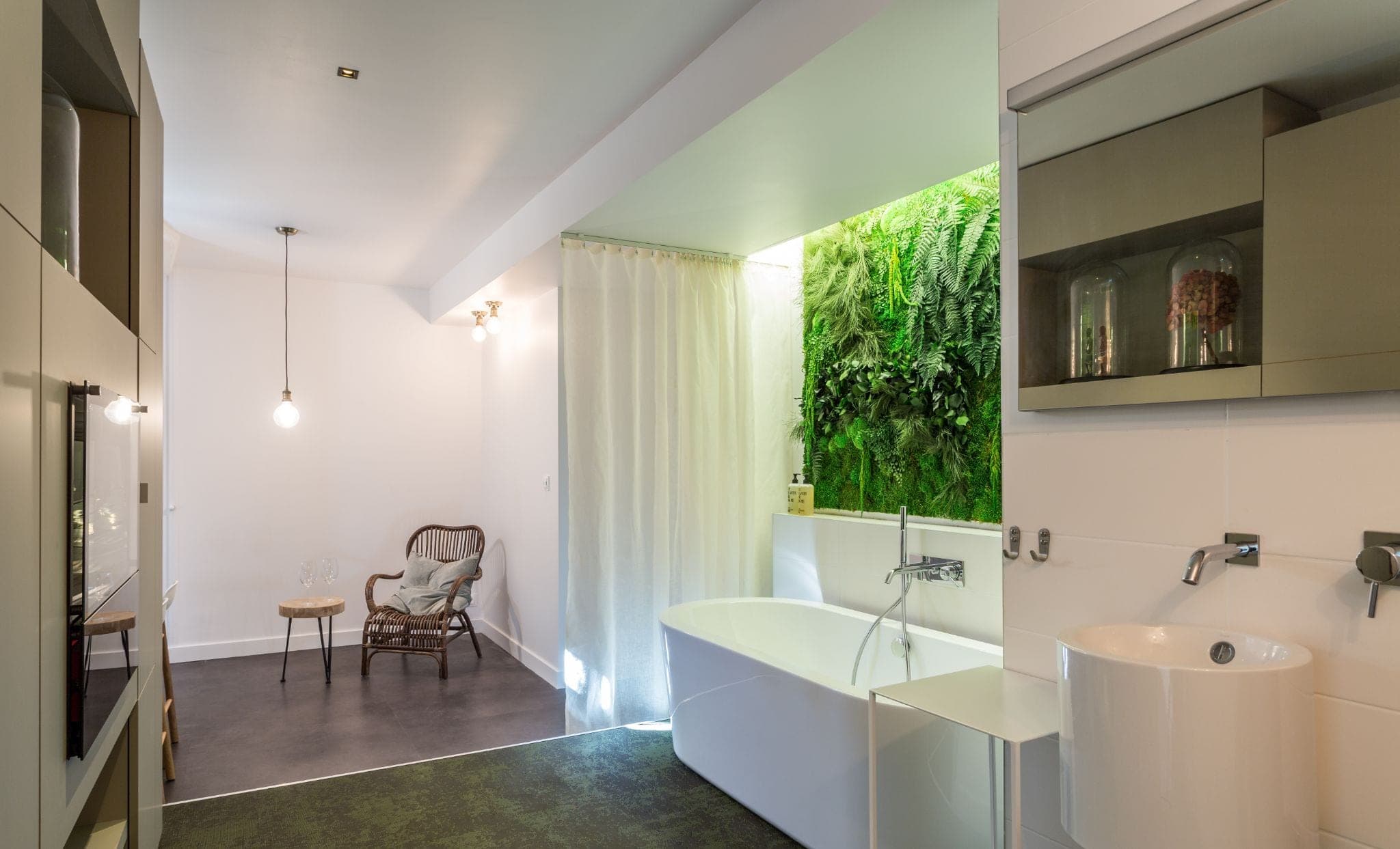 Salle de bain avec baignoire îlot, mur végétal et vasques blanches